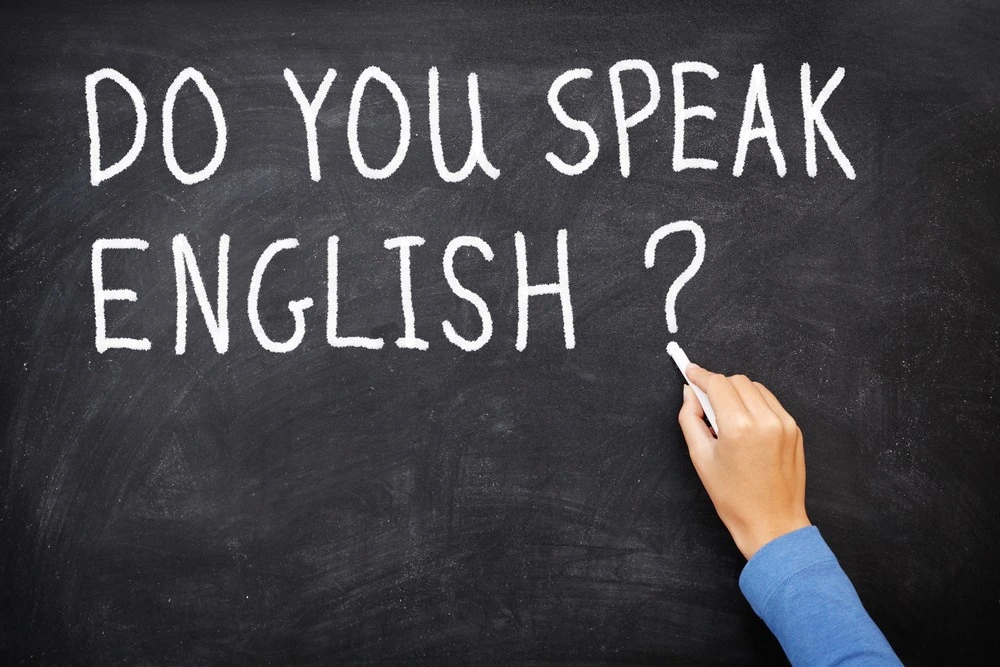 Вопрос 'Do you speak English?', написанный мелом на доске